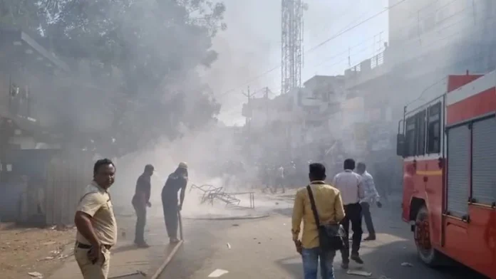 आगजनी और हिंसा के बाद परभणी में जलती हुई गाड़ी और तोड़ी गई दुकानों का दृश्य।